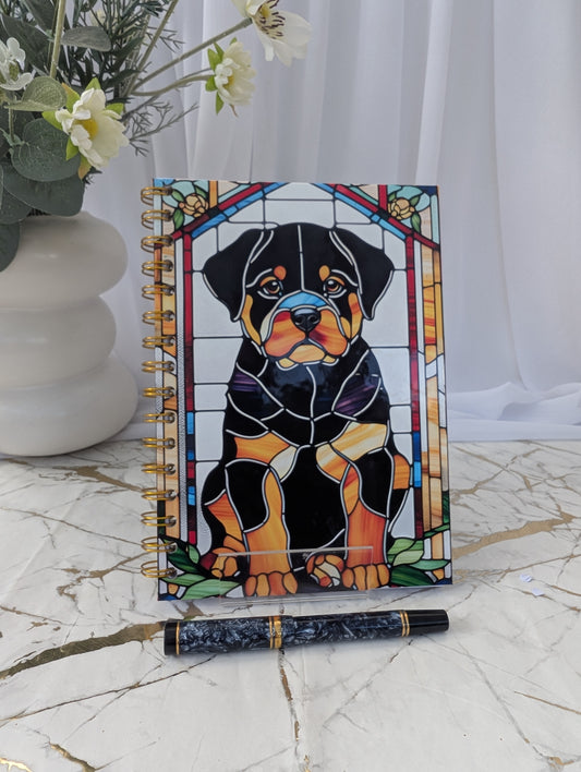 Cool dog gift - Notebook with stained glass-style Rottweiler design on a marble surface with a pen and flowers.