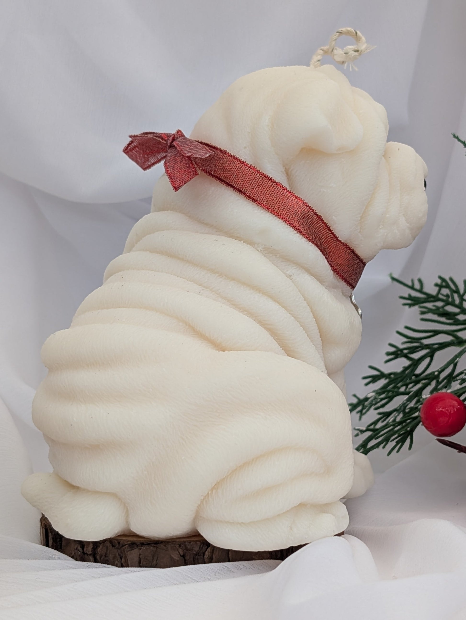 Back view of moulded Shar-Pei candle with red ribbon and silver colour charm around neck