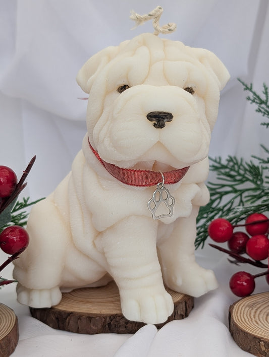 Front view of moulded Shar Pei candle with open work paw print silver colour charm on red ribbon