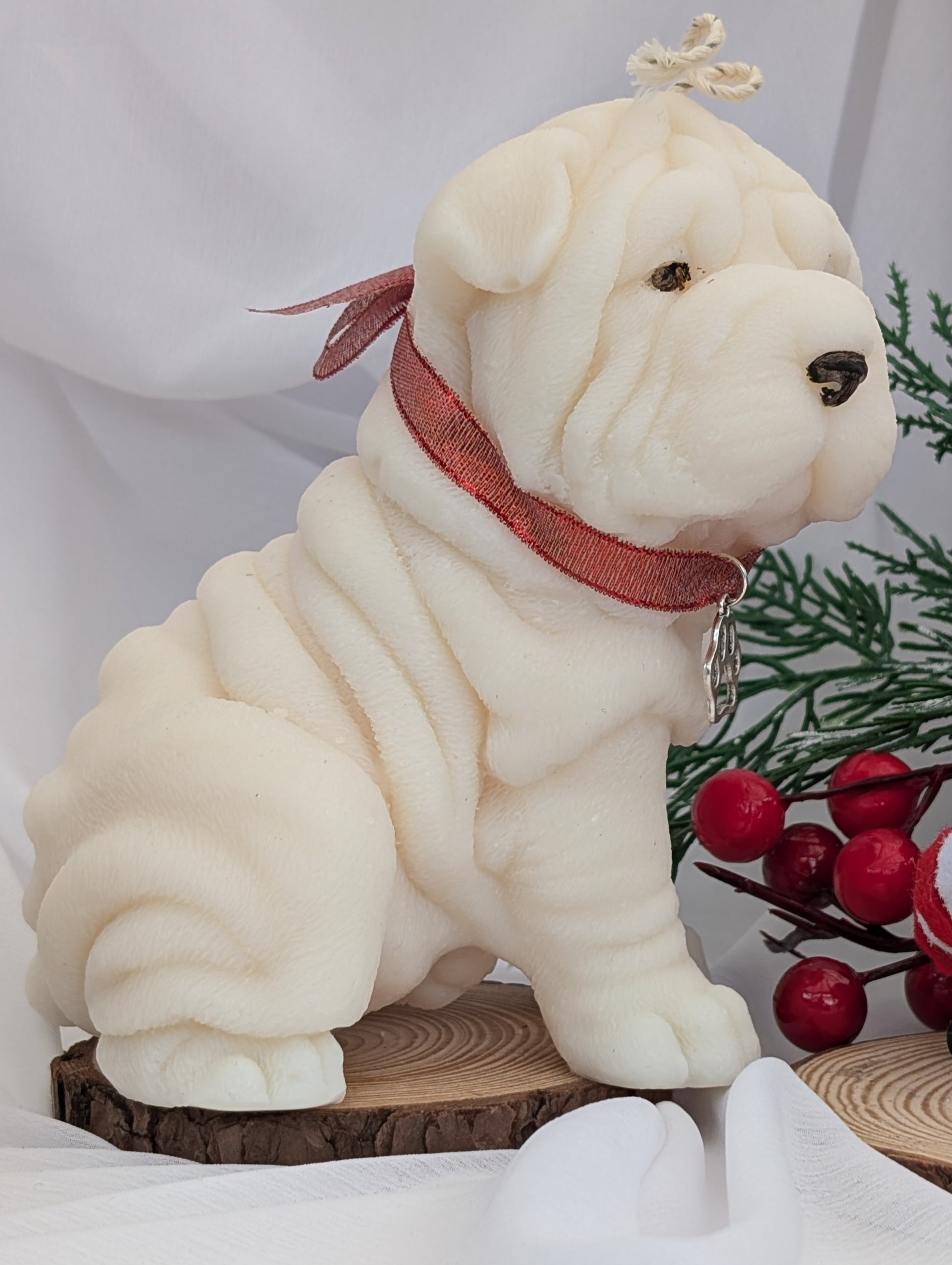 Side view of Shar Pei moulded candle with red ribbon and silver charm around neck