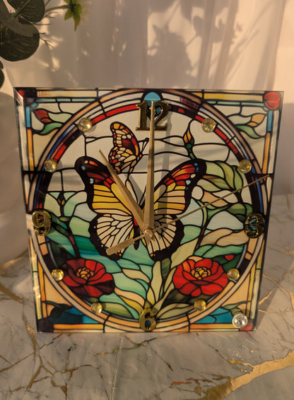Close-up of stained glass-style butterfly clock with vibrant blue and purple wings on a freestanding base.