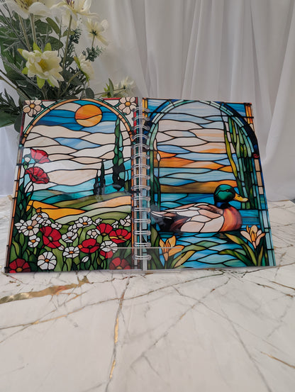 Front and back view of a handmade spiral bound, duck-themed, stained glass glossy notebook.  Open to show front and back