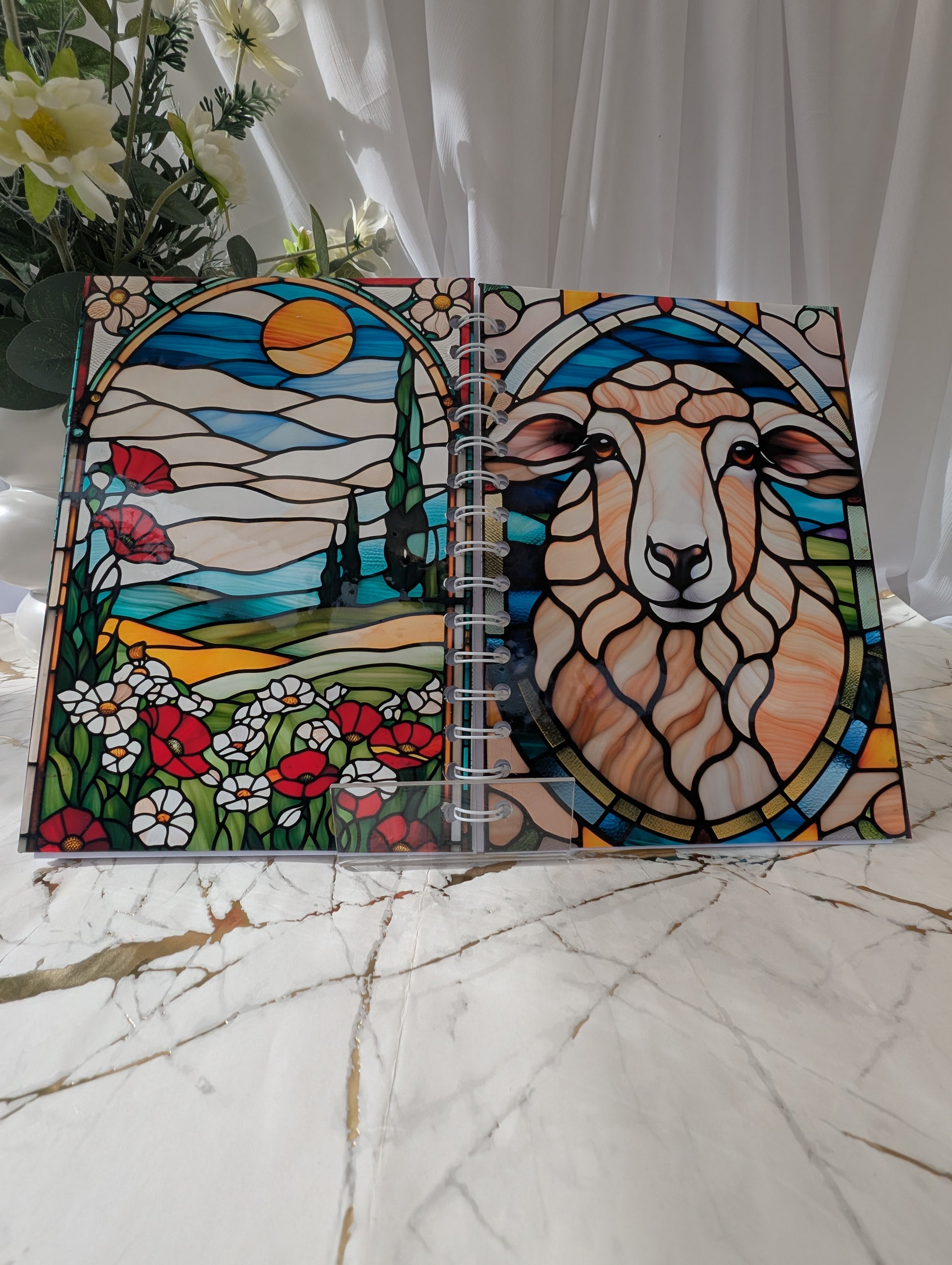 Front and back view of colourful A5 handmade glossy sheep notebook with faux stained glass design, shown open to display both covers.