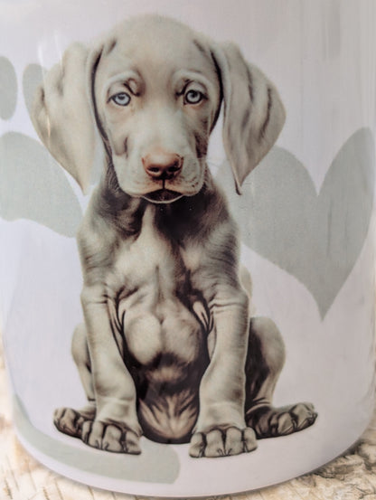 close up of White Ceramic Weimaraner Dog Puppy mug with background of soft grey hear, paw and bone print