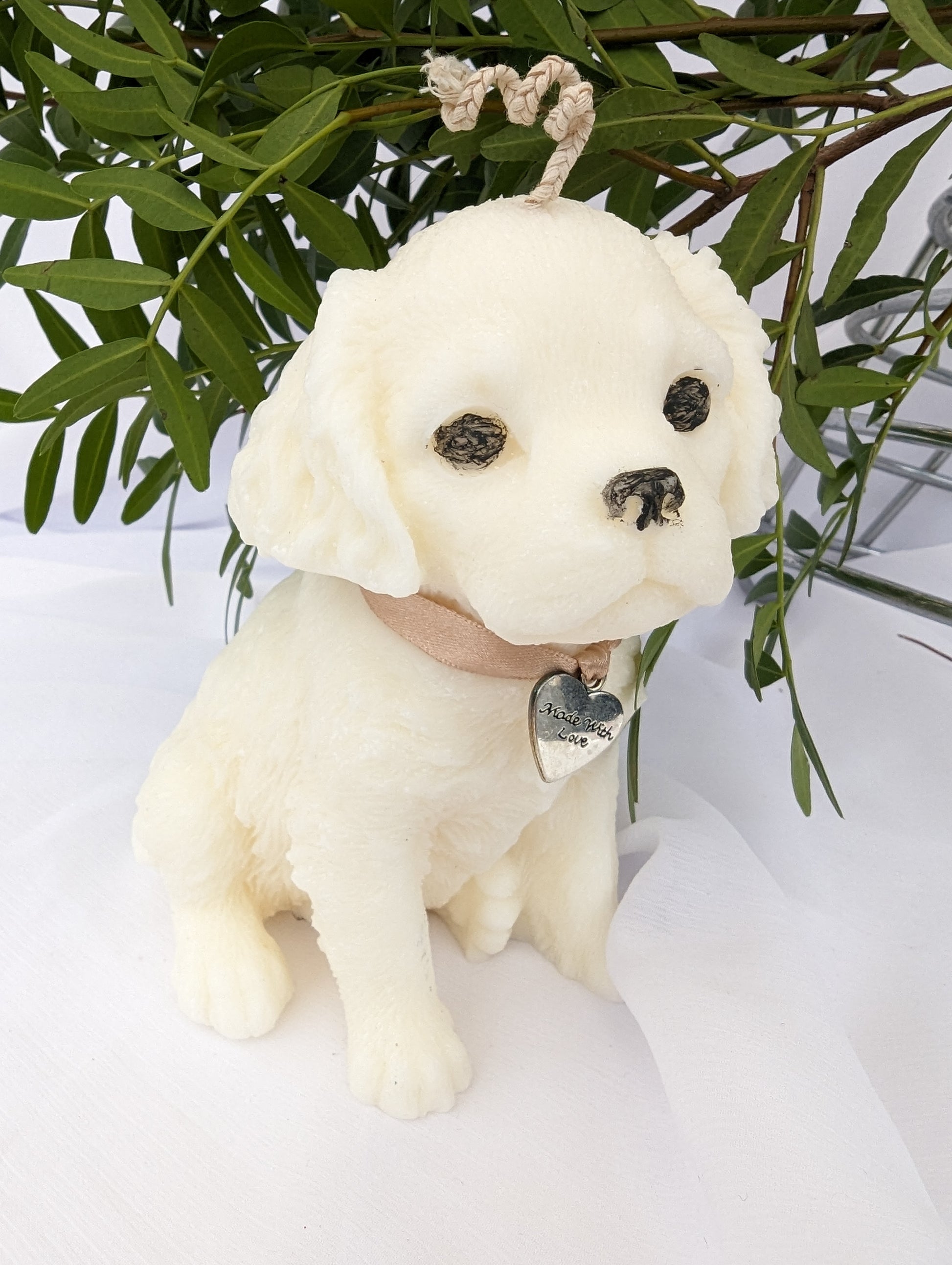 side view of Cavalier King Charles Spaniel Puppy Candle wearing ribbon and charm around neck