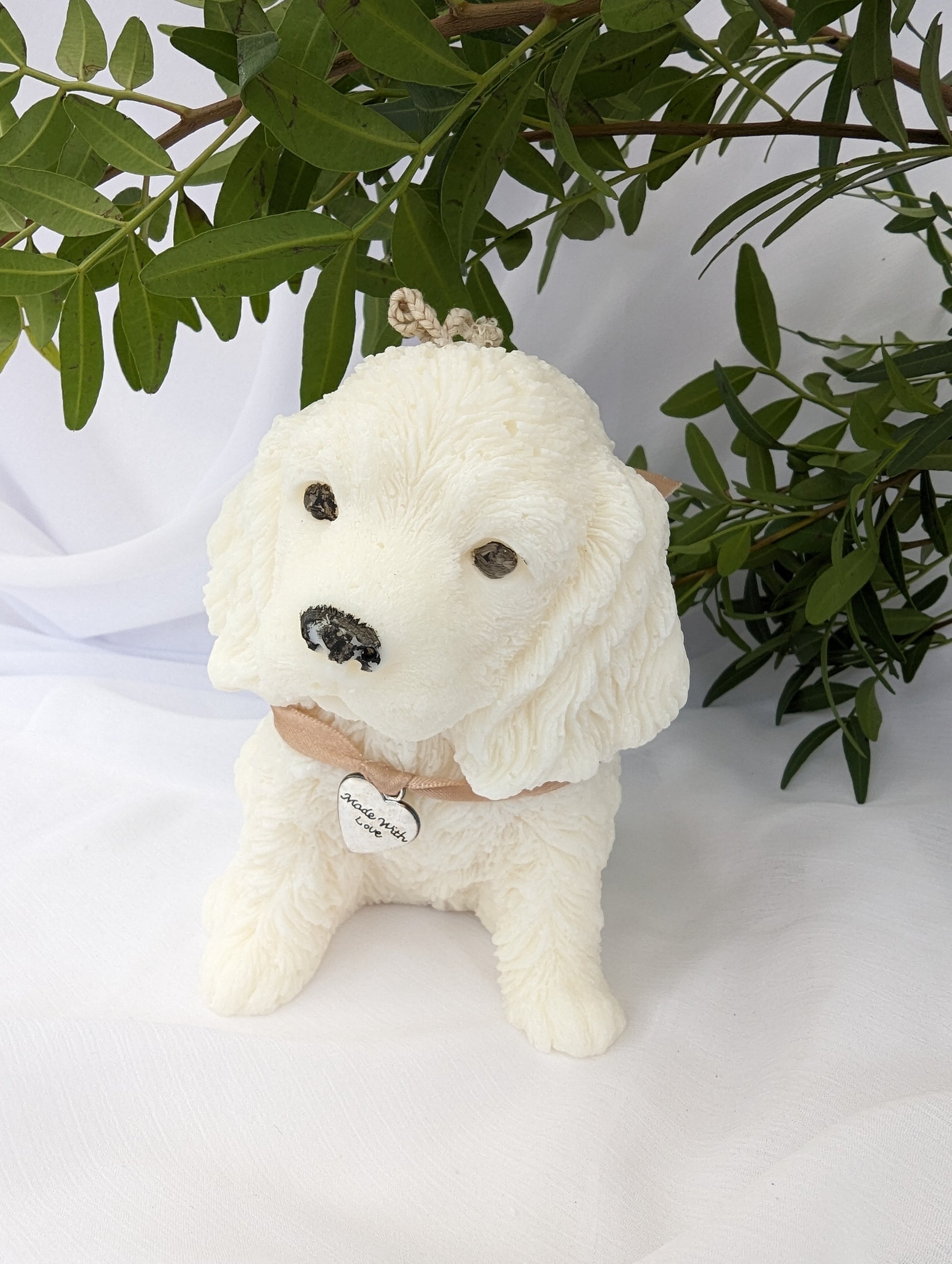 Side view of moulded cocker spaniel puppy candle with ribbon and charm detail around neck
