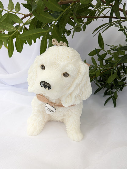 Side view of moulded cocker spaniel puppy candle with ribbon and charm detail around neck