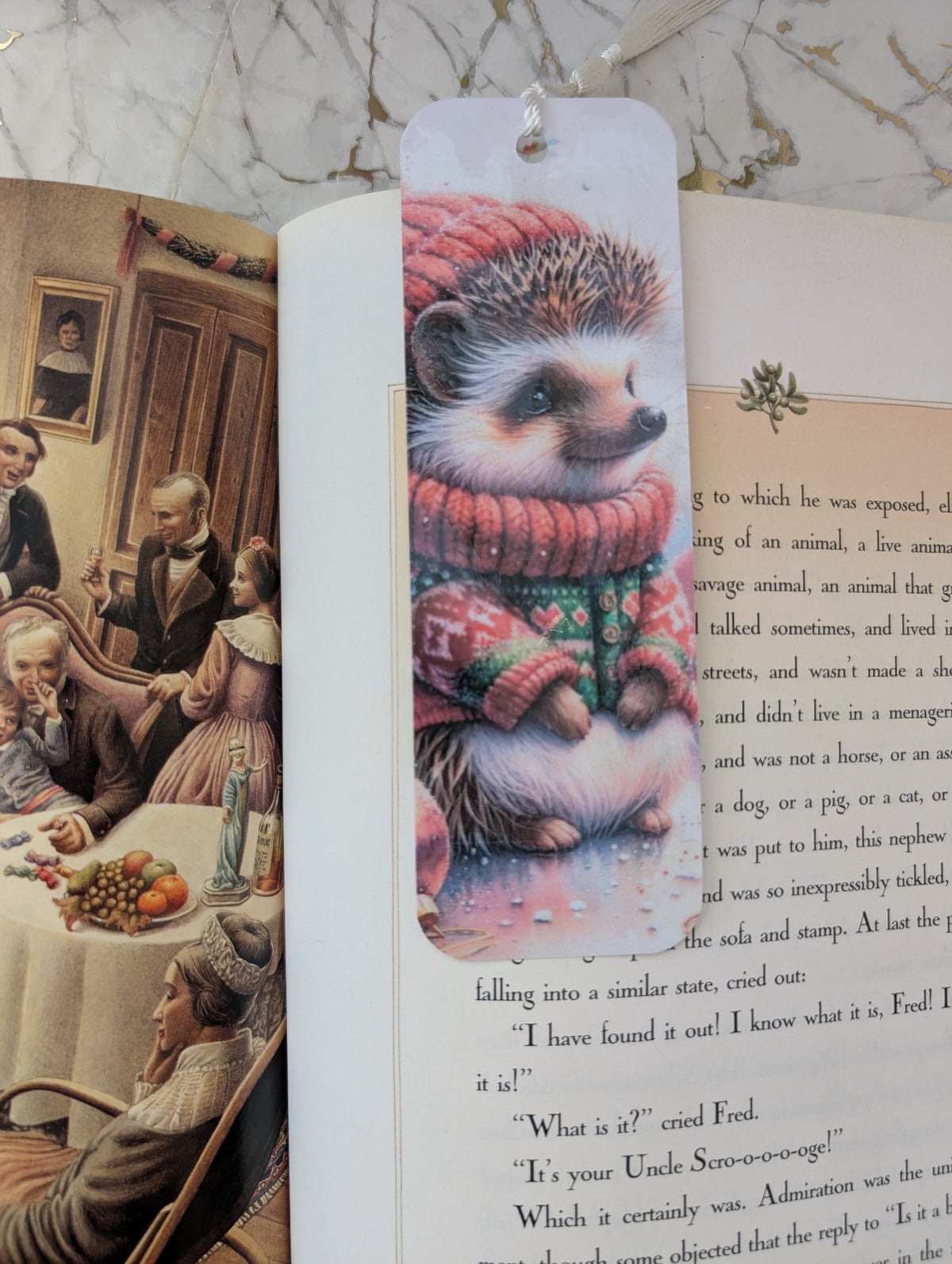 Cute Hedgehog lover gift. A rectangular bookmark featuring a whimsical illustration of a hedgehog wearing a red knit sweater and matching red hat, shown resting on an open book with printed text and holiday-themed artwork.