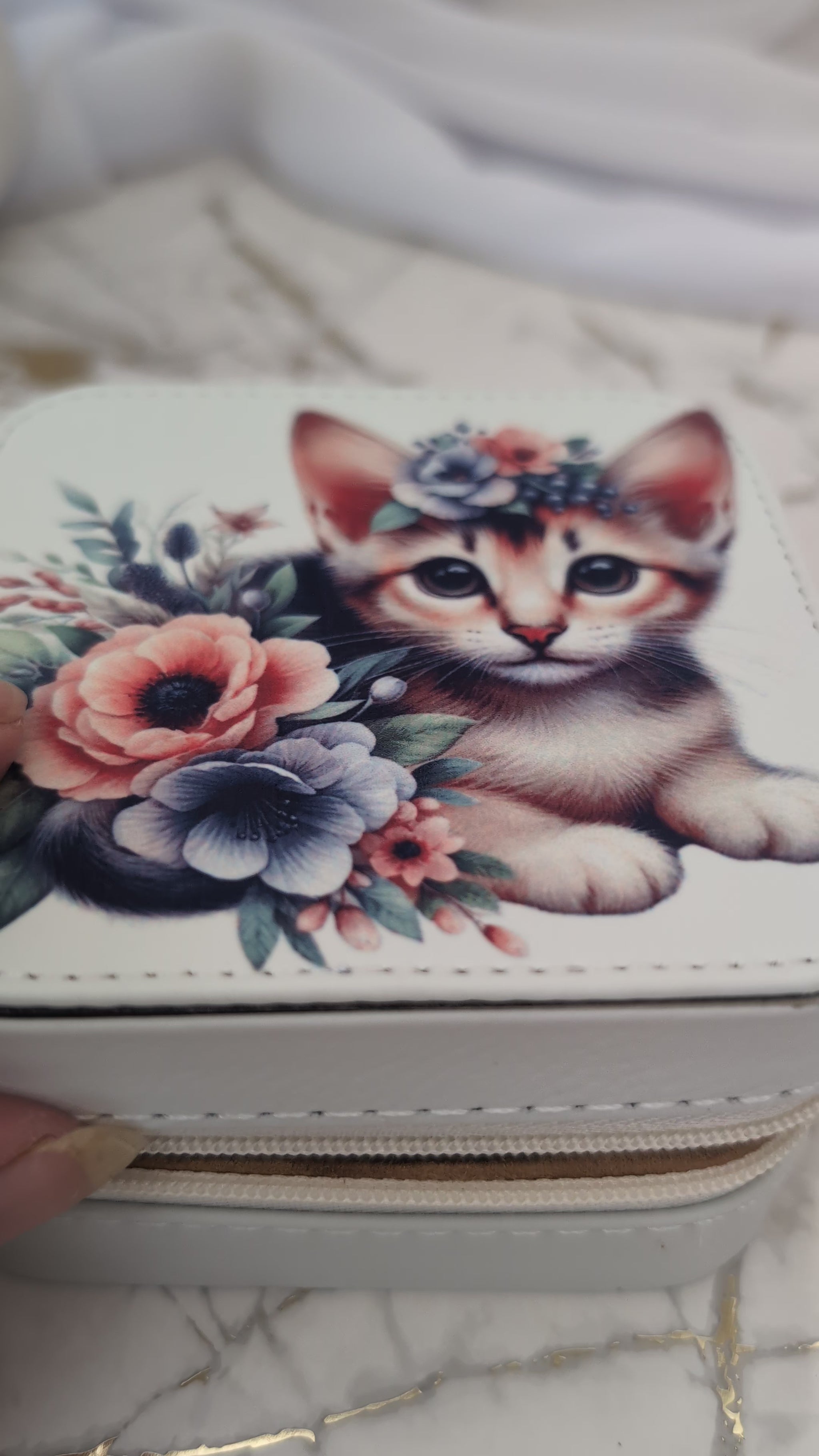 Cream faux leather travel jewellery box with kitten design - shown opening box to view inside compartments with jewellery