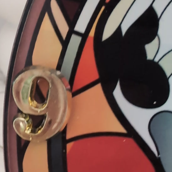 video of Dalmation wall clock, stained glass style in red tones, with gold coloured numerals and black hands.  20cm diameter round