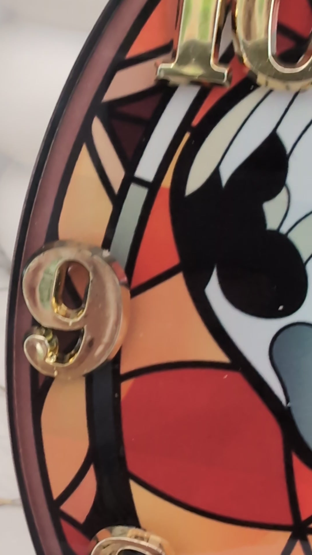 video of Dalmation wall clock, stained glass style in red tones, with gold coloured numerals and black hands.  20cm diameter round
