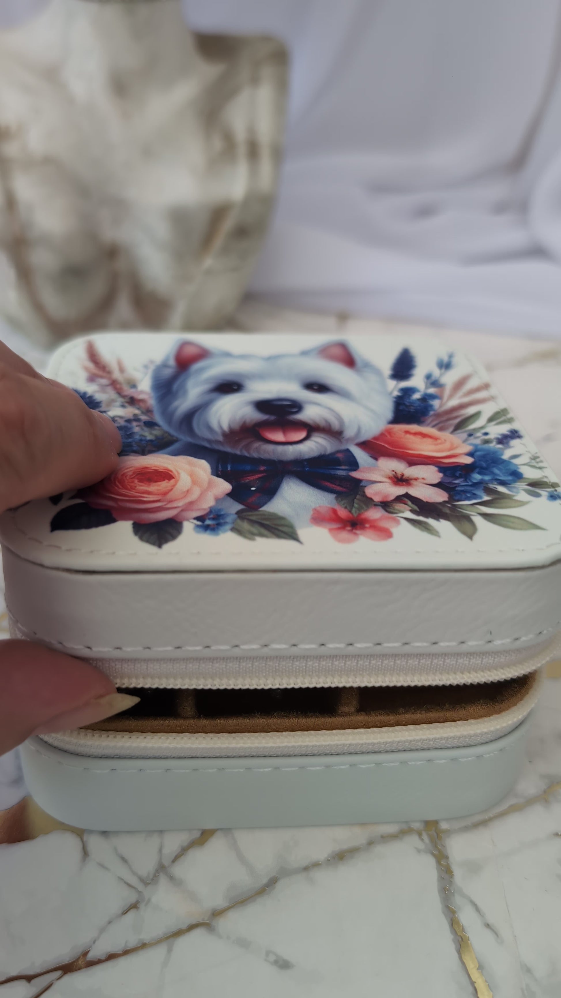 Someone opening the westie travel jewellery box to show jewellery inside the box