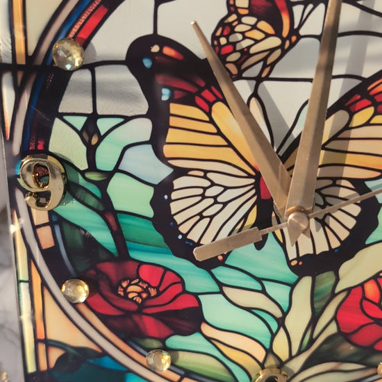 stained glass-style butterfly clock slowly rotating to display its vivid colours and freestanding design.