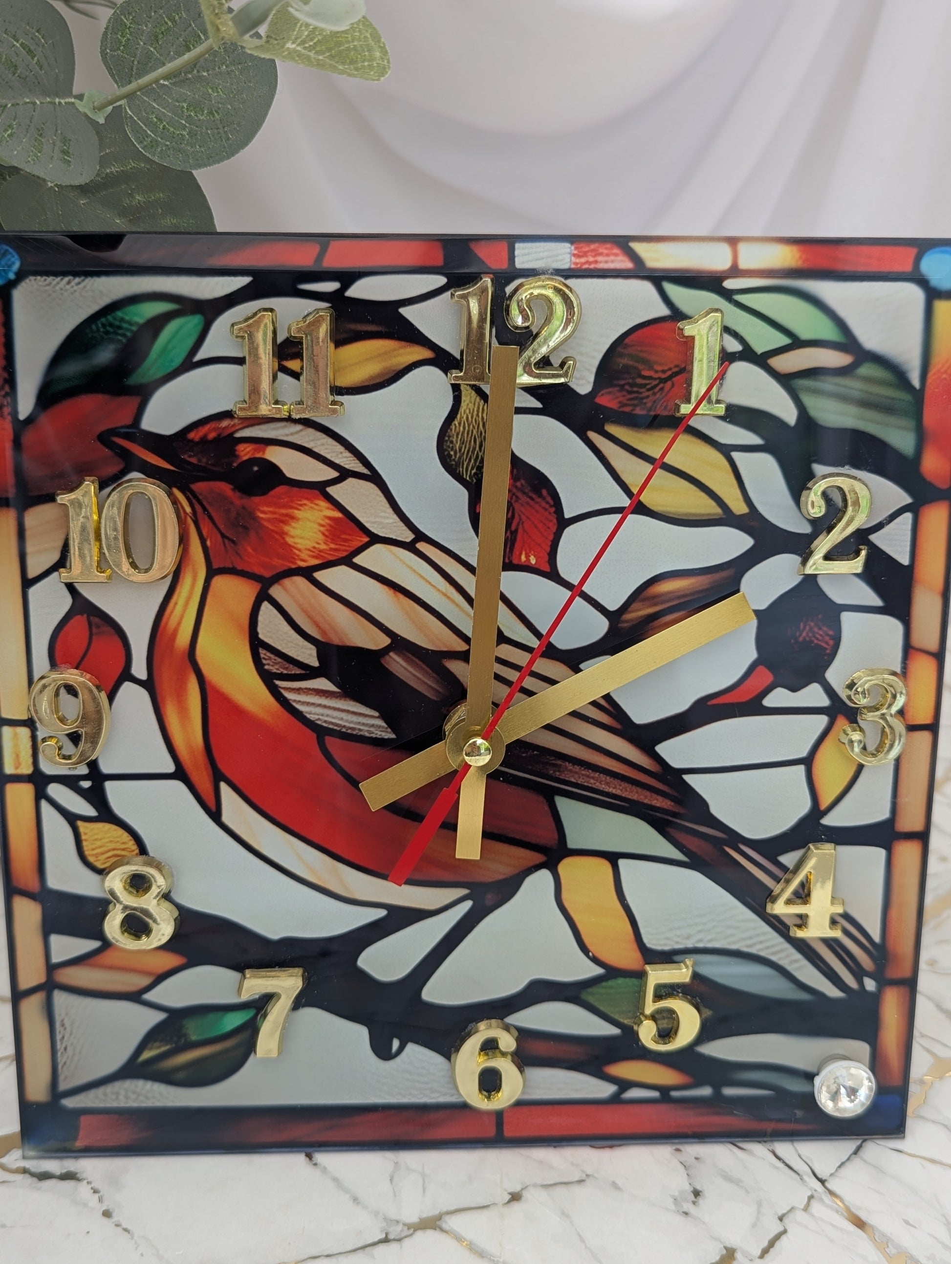 Close-up of robin clock showing detailed art glass pattern and rustic woodland charm.