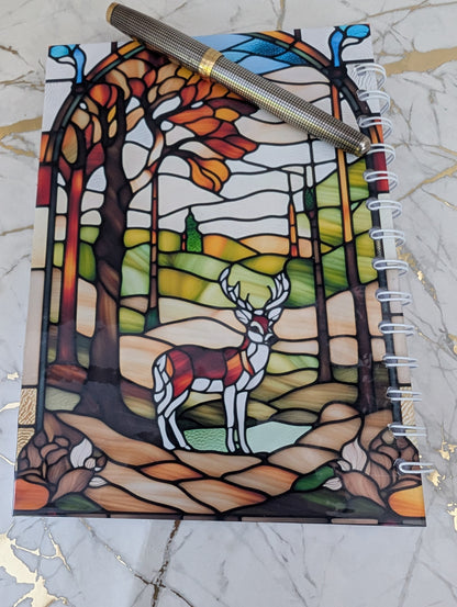 Back cover of stained glass highland cow notebook - showing forest scene with stag